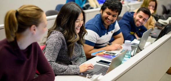 People sitting together and smiling in a lecture hall